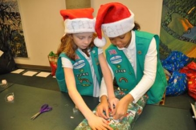 two girl scouts wrapping a present