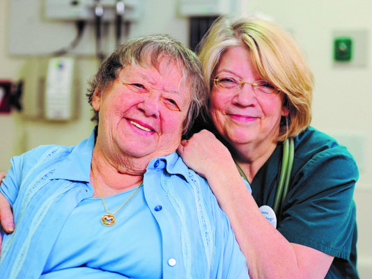 A nurse and elderly woman posing together for a photo