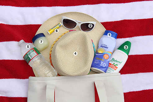beach supplies such as a towel, sunglasses, and sunscreen