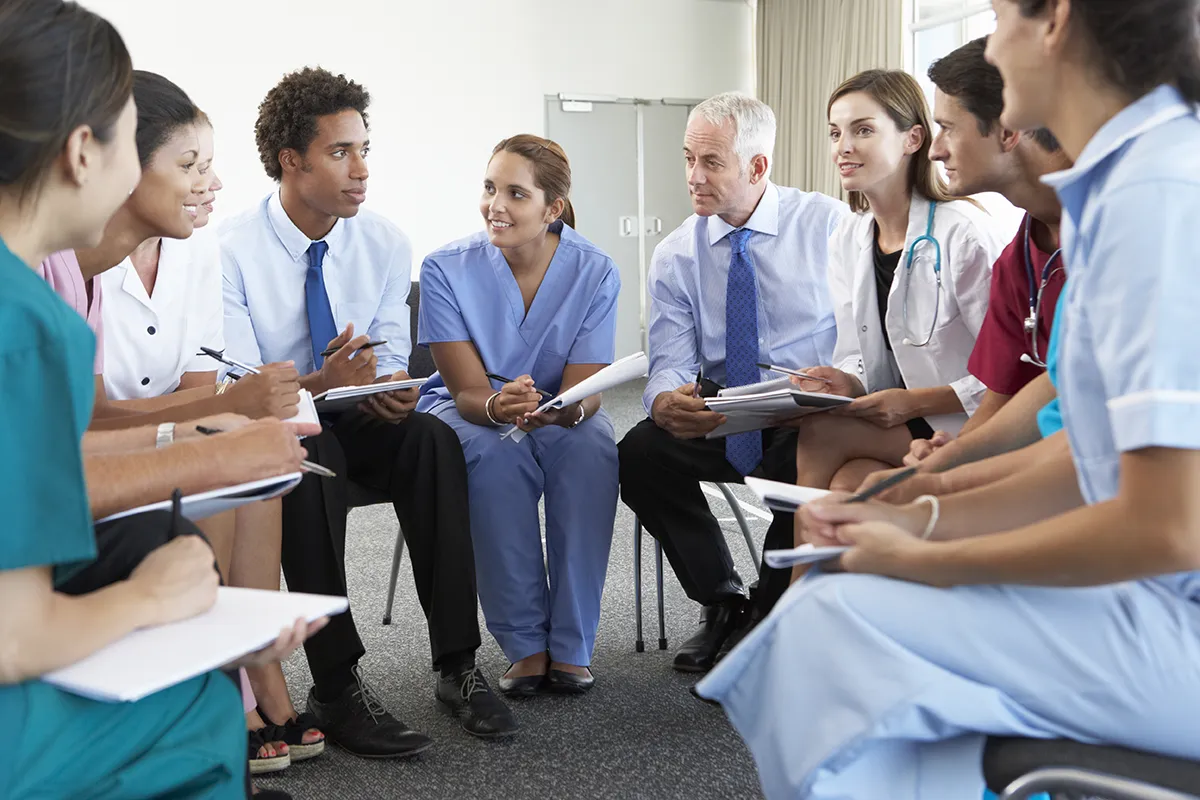Doctors sitting in a circle taking notes