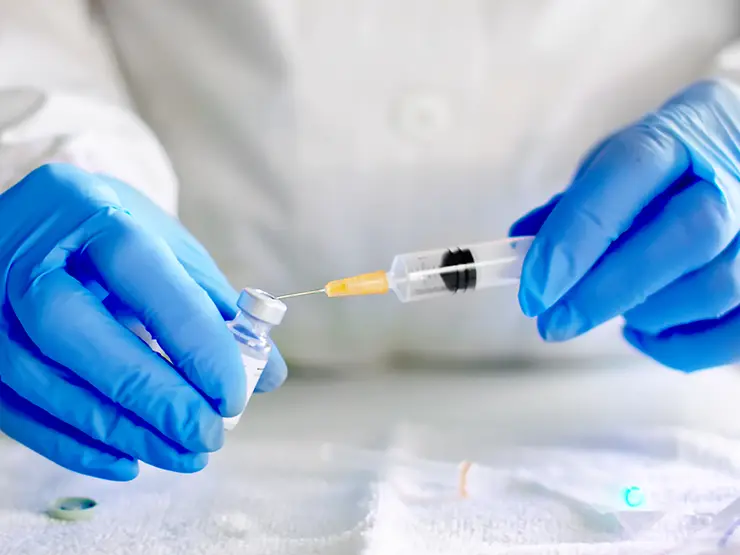 image of person inserting syringe into vial