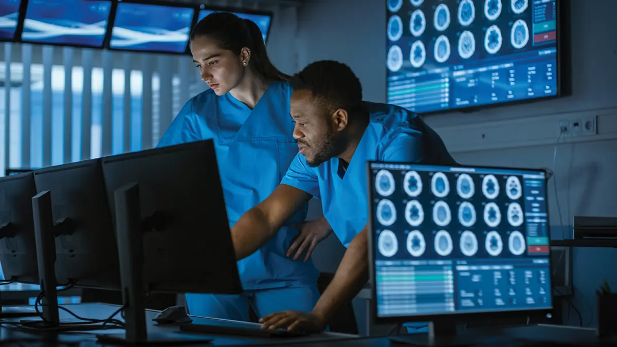 physician looking at computer screens and xrays