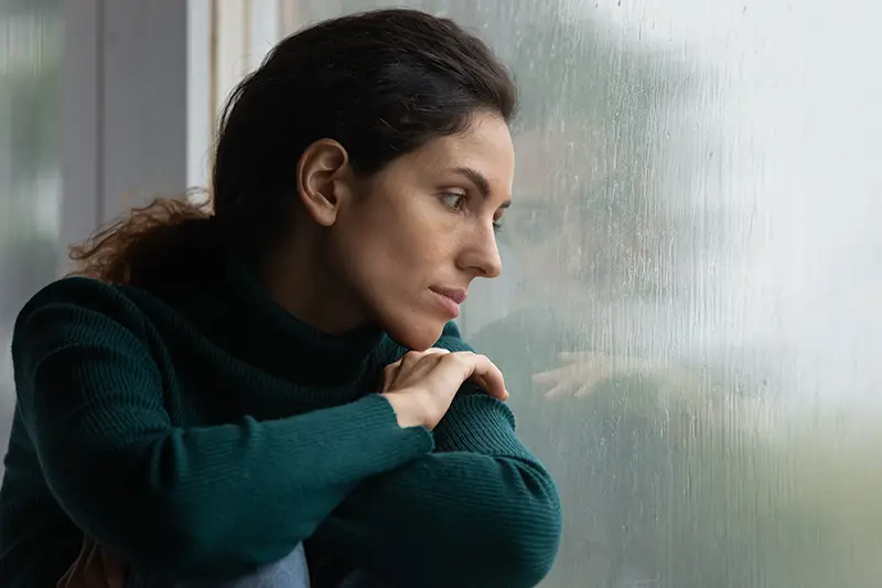 image of woman looking out the window