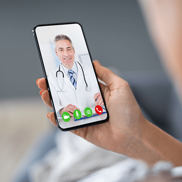 A video call with a male doctor on a phone.